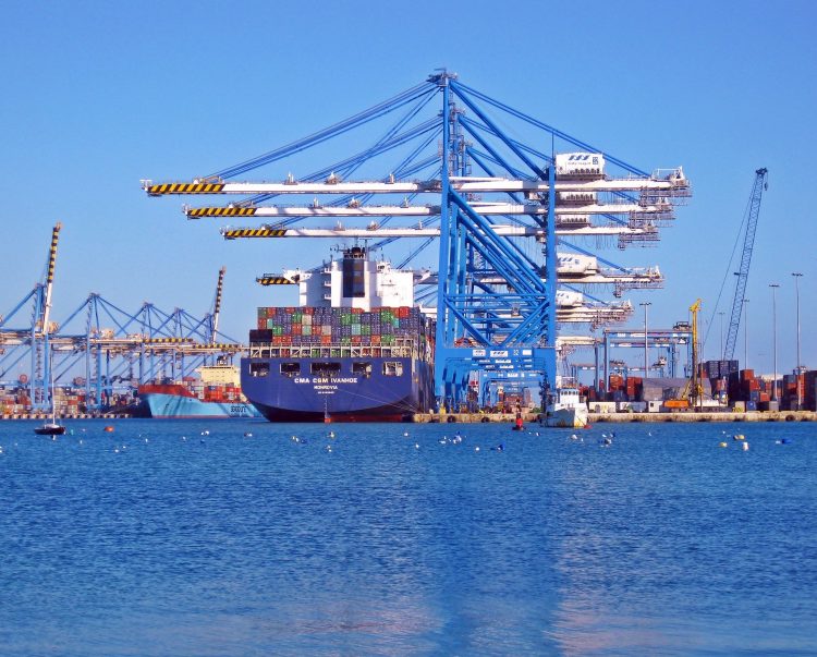 Imagem de um navio carregado com cargas em um grande porto. Ilustra ação aduaneira