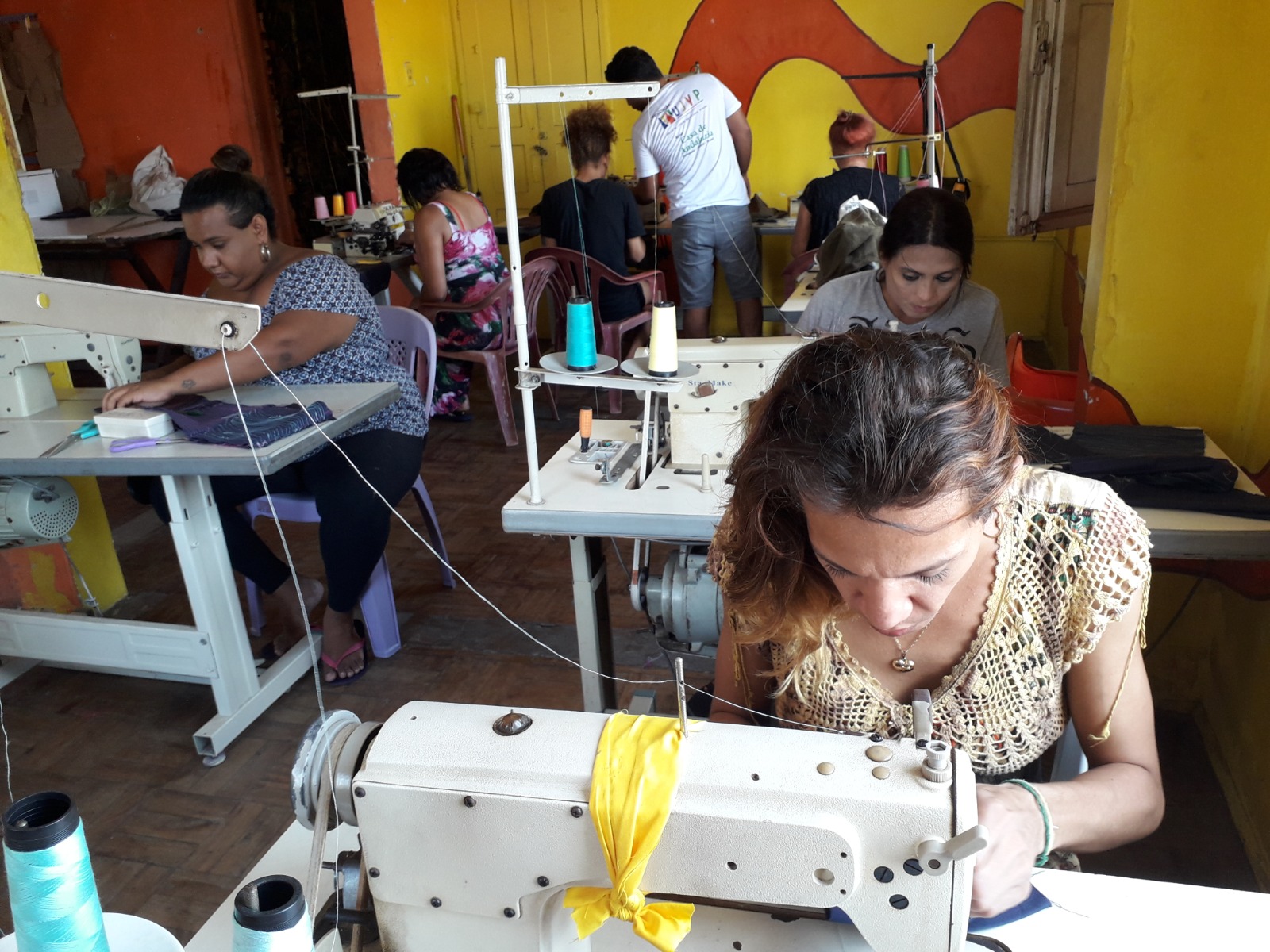 Alunas trabalham em máquinas de costura durante curso de Moda e Costura para Pessoas Trans