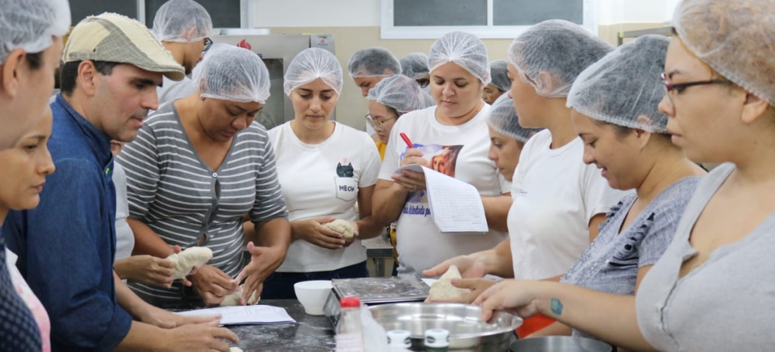 Adultos em uma cozinha aprendendo lições de gastronomia