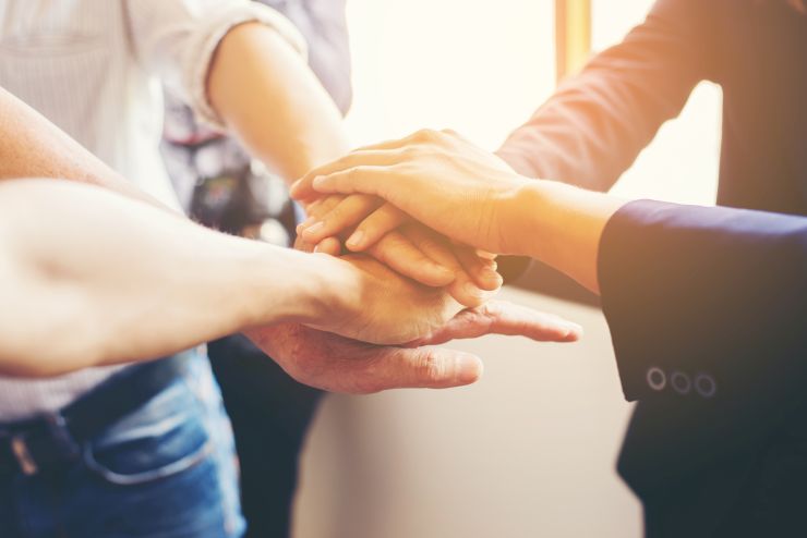 Mãos de profissionais unidades, representando assuntos de artigo sobre como liderar em uma pandemia