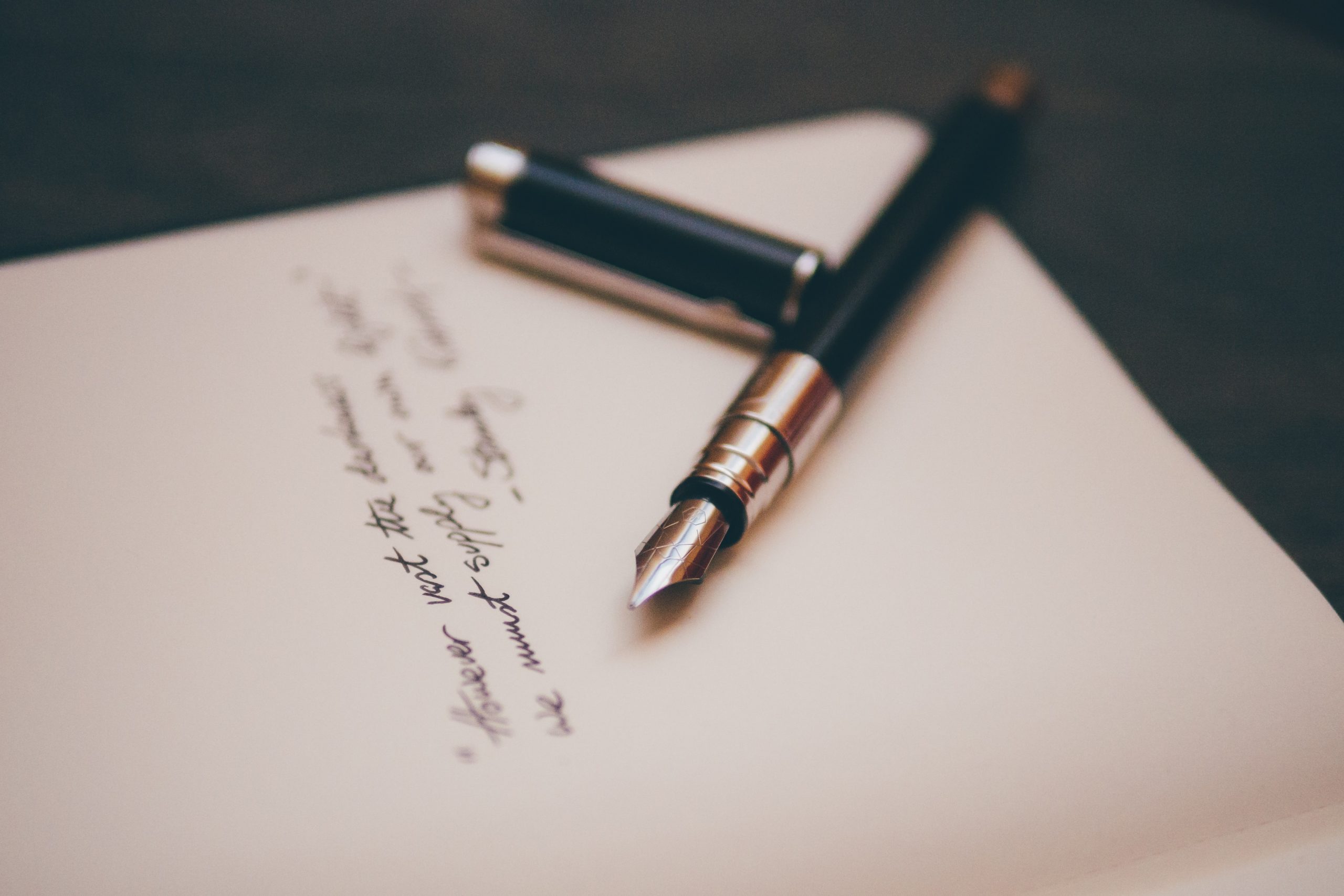 papel, caneta e uma poesia escrita 