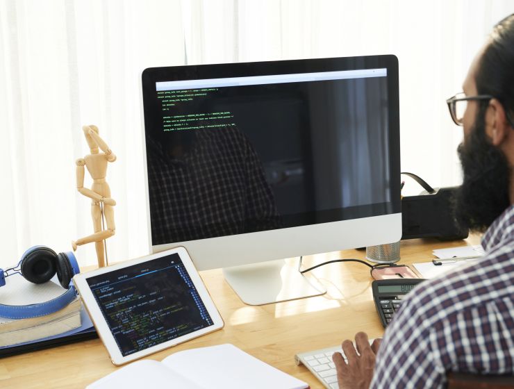 Homem em frente a um computador com tela de programação Java aberta; Coders seleciona para cursos de programação