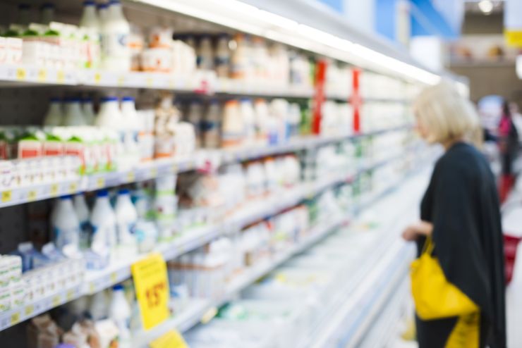 Mulher no supermercado vendo laticínios, que são produzidos graças à Zootecnia