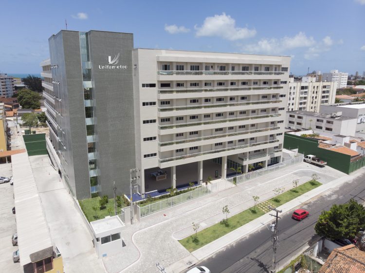 Na imagem, o campus Carneiro da Cunha da Unifametro. O prédio possui sete andares e é pintado nas cores cinza e branca.